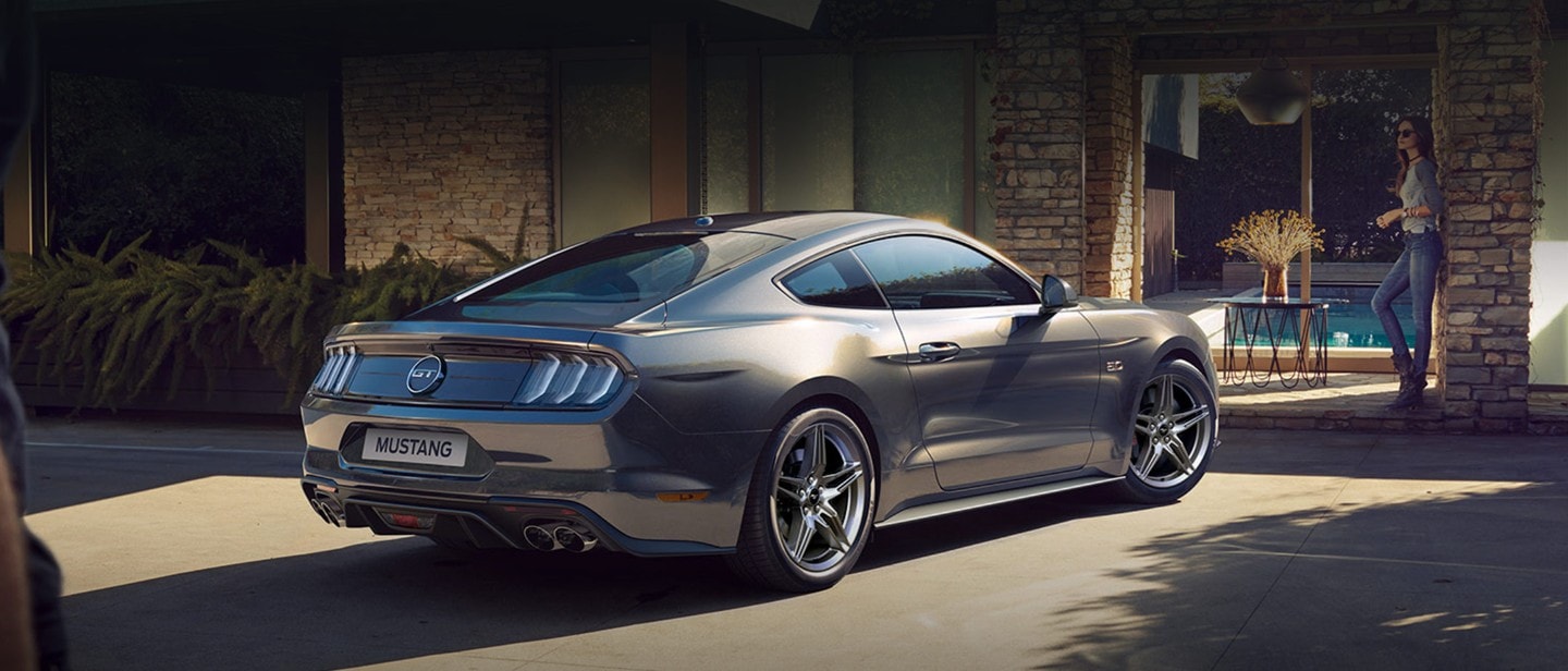Ford Mustang parkeret ude foran et luksuriøst hjem