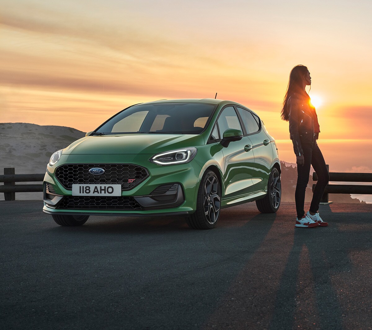 Woman standing next to a Fiesta ST during sunset