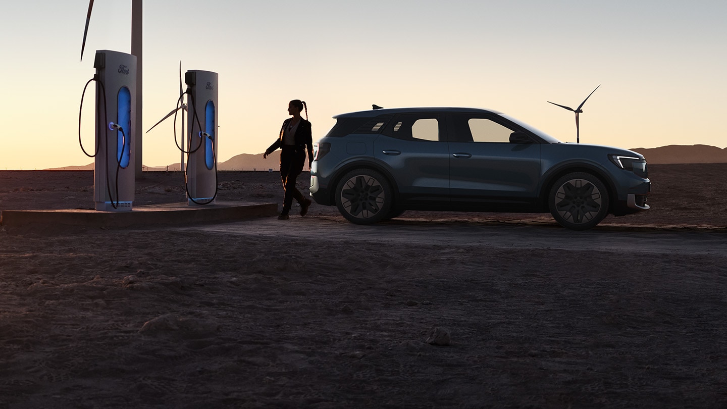 A person charging the Ford Explorer® at sunset