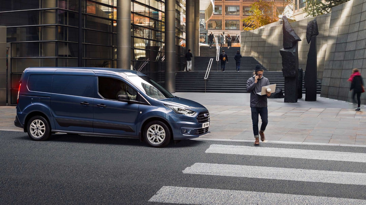 Ford Transit Connect in front of zebra crossing with pedestrian