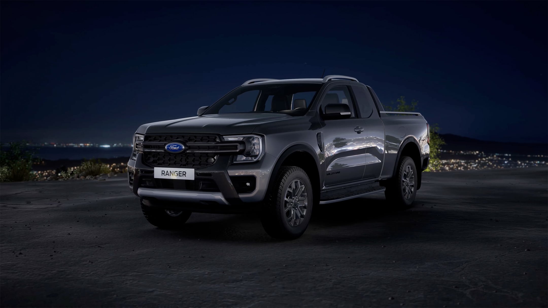All-New Ford Ranger in carbonized grey front 3/4 view parked on cliff overlooking city at night